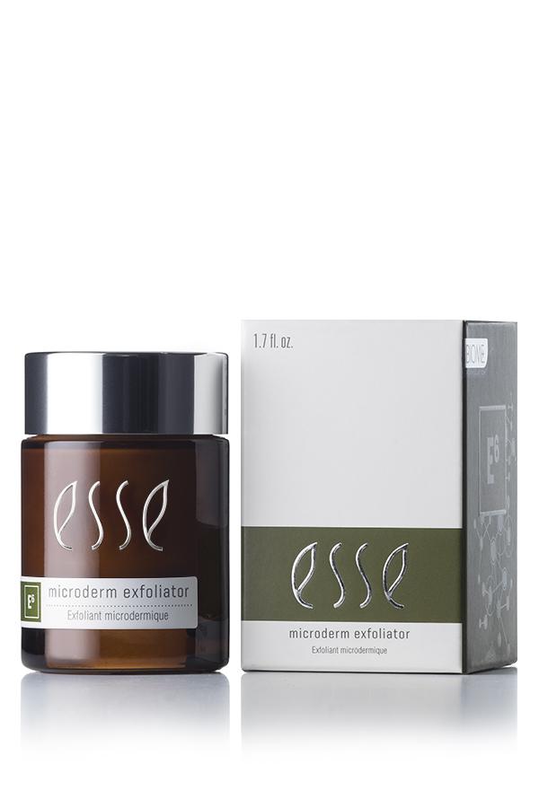 A brown jar of Esse Microderm Exfoliator with a black lid sits beside its packaging. The box is white with grey and green accents, showcasing the same product name and branding. Both the jar and the box have a glossy finish that reflects the light.