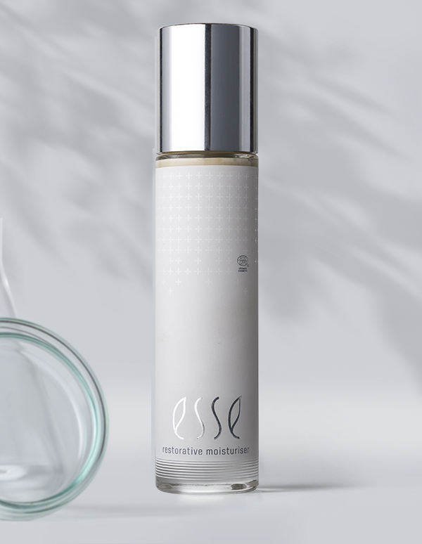 A sleek, cylindrical bottle of Esse Restorative Moisturiser with a silver cap and minimalist white label stands against a light gray background with subtle shadows.
