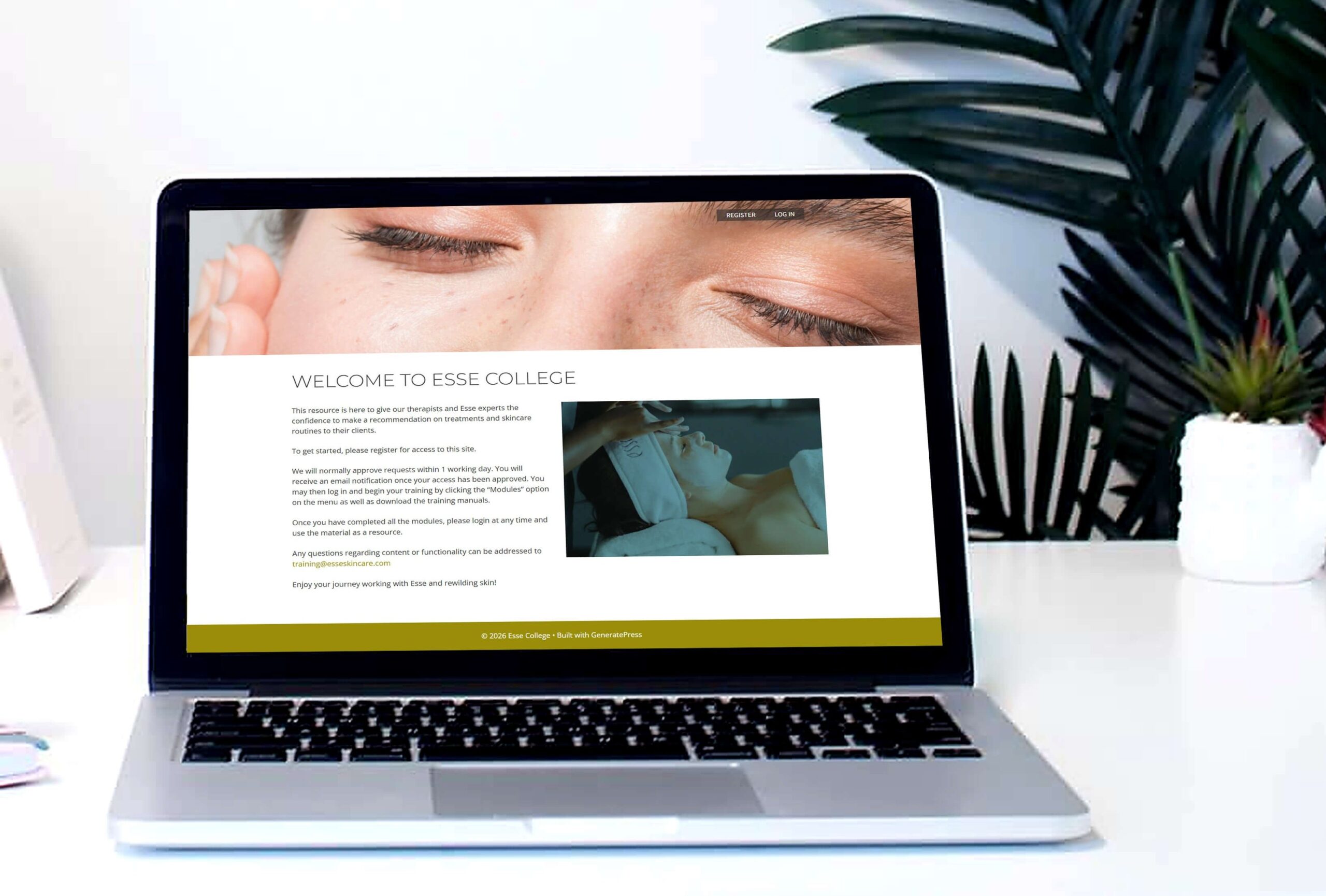 A laptop on a white desk displays a website with an image of closed eyes and another of skincare treatment, next to a plant and a white pot with succulents.