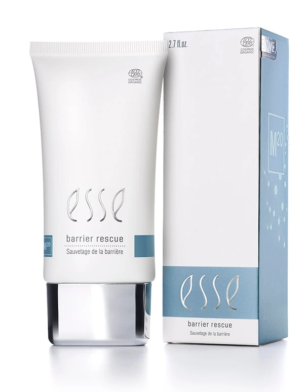 A white tube labeled "Esse Barrier Rescue" stands next to its matching box, both showcasing minimalist blue and grey accents similar to the elegant design found in the Esse Bakuchiol Serum line. This skincare product's packaging features both English and French text.