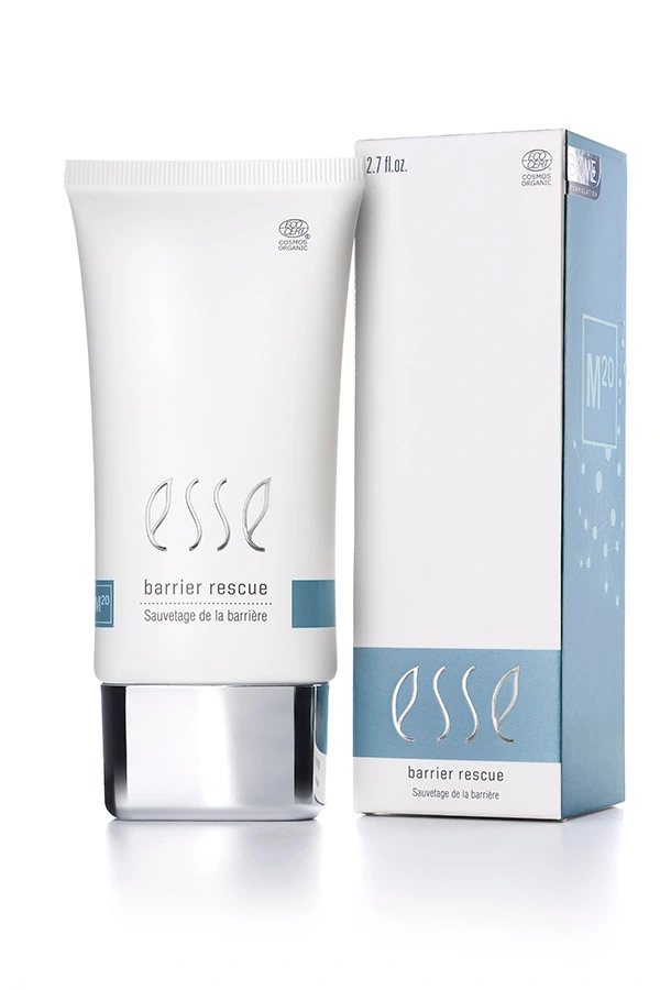 A white tube labeled "Esse Barrier Rescue" stands next to its matching box, both showcasing minimalist blue and grey accents similar to the elegant design found in the Esse Bakuchiol Serum line. This skincare product's packaging features both English and French text.